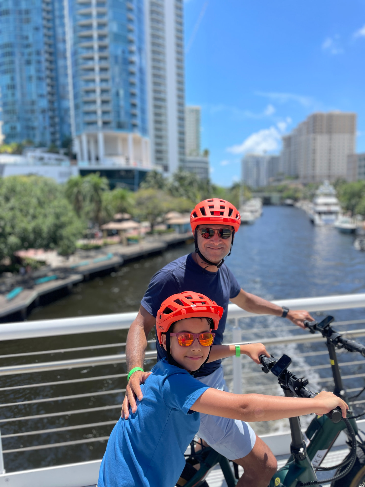 Father and son riding eBike rentals over the Fort Lauderdale New River bridge